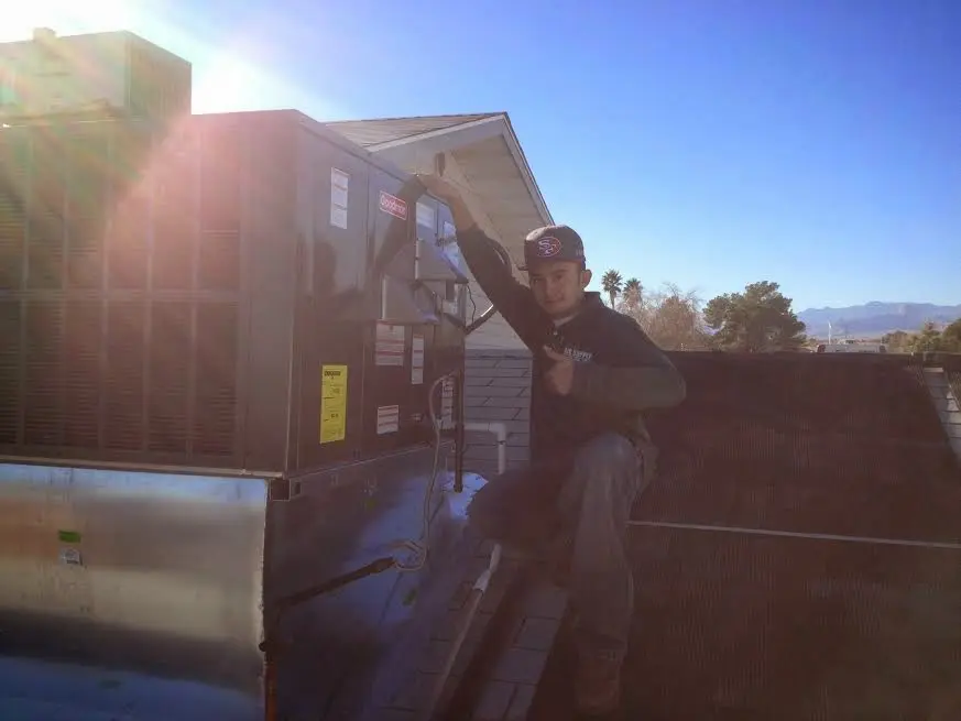 HVAC technician performing AC Tune-Up on a rooftop unit in Montrose