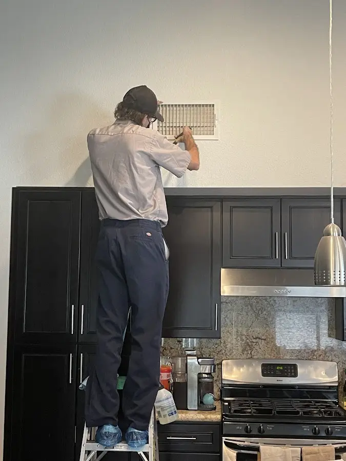 Technician inspecting an air vent during HVAC service in Montrose